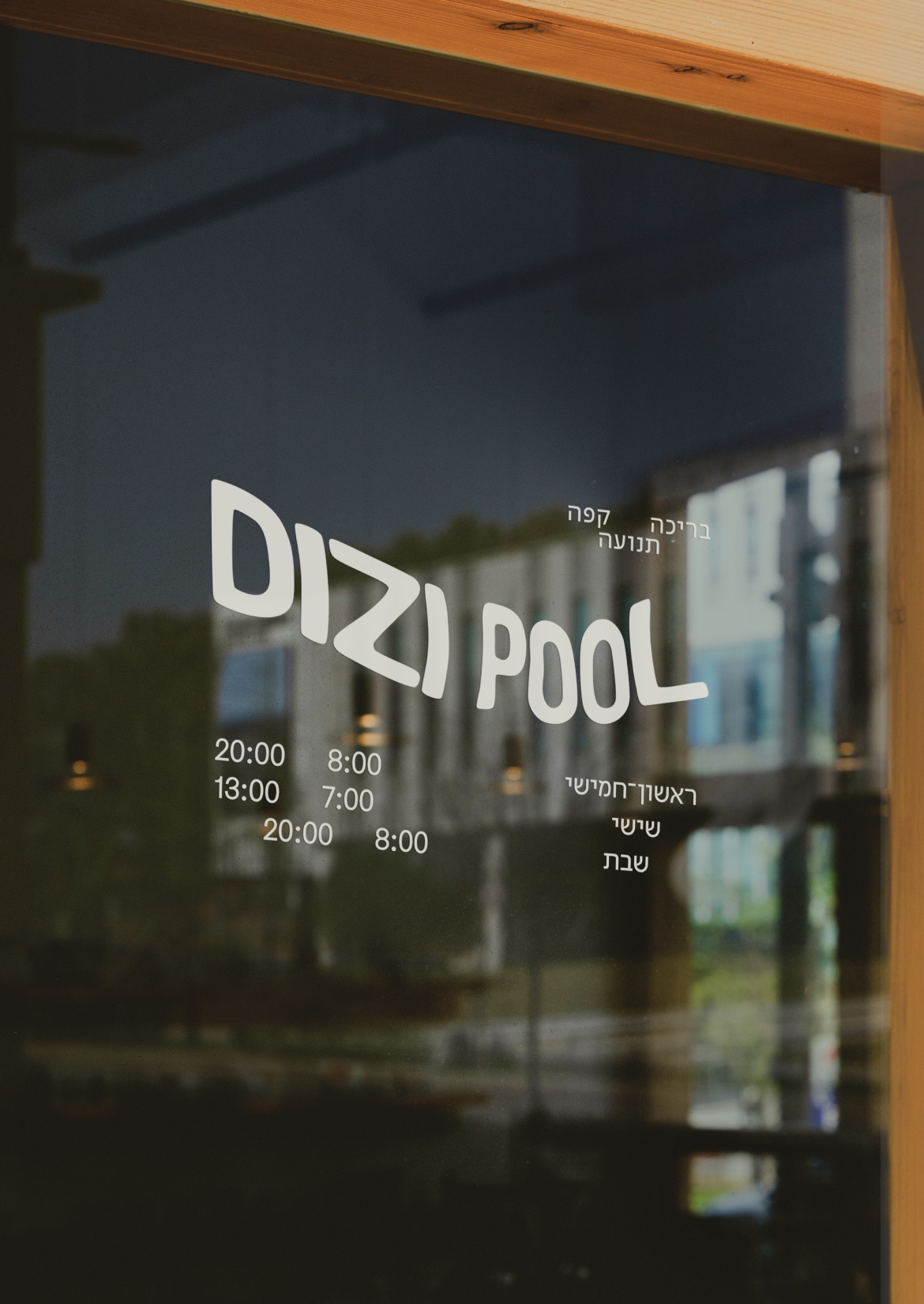 Dizi Pool logo and opening hours on a glass door