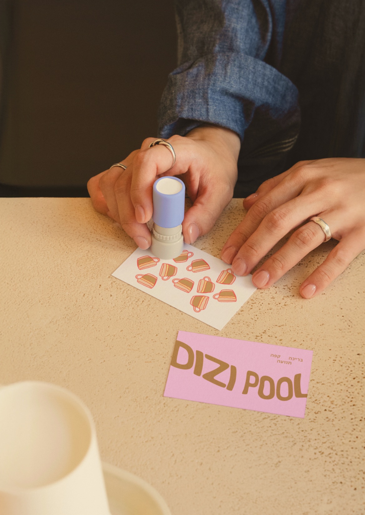 Coffee punch card being stamped, next to a Dizi Pool business card
